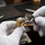 Ihr diskretes Pfandleihhaus & Goldankauf Juwelier prüft Goldring mit Lupe – seriöser Goldankauf in Berlin